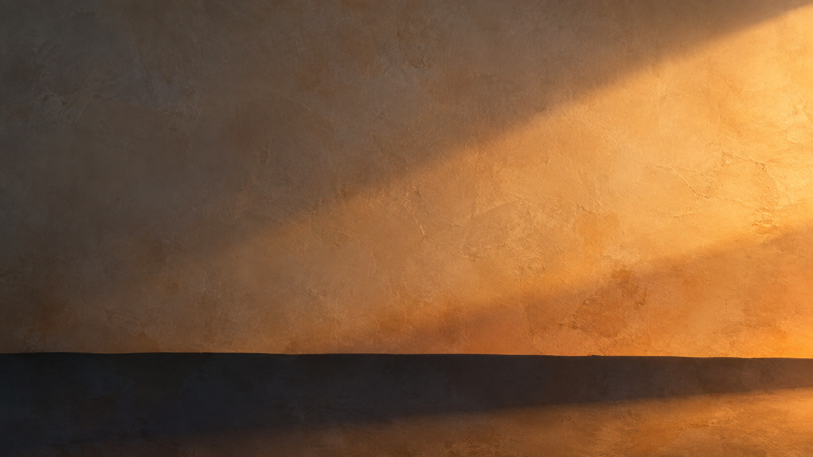 Amber light crossing a mineral wall at dusk